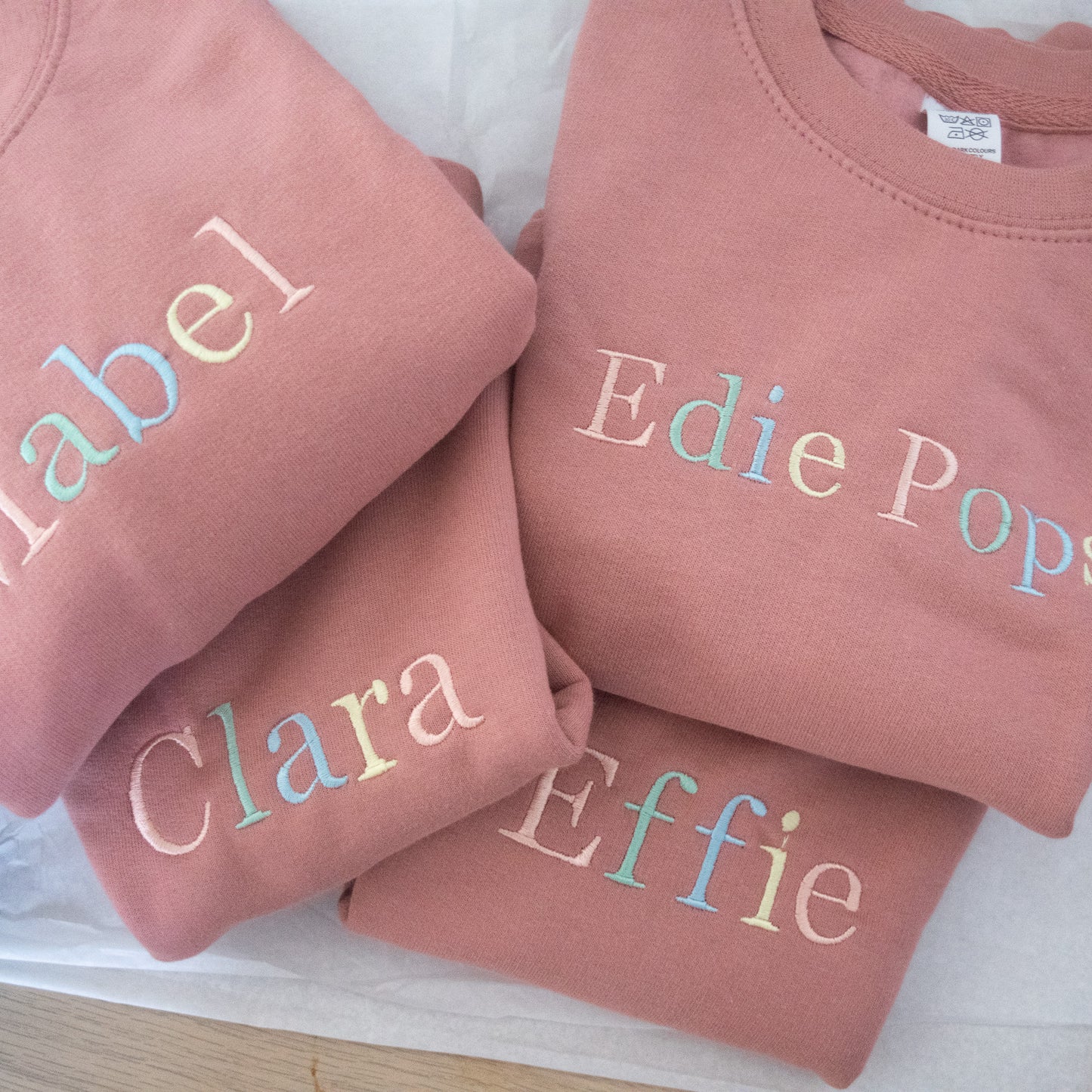 kids custom embroidered personalised jumper in pink with rainbow pastel thread