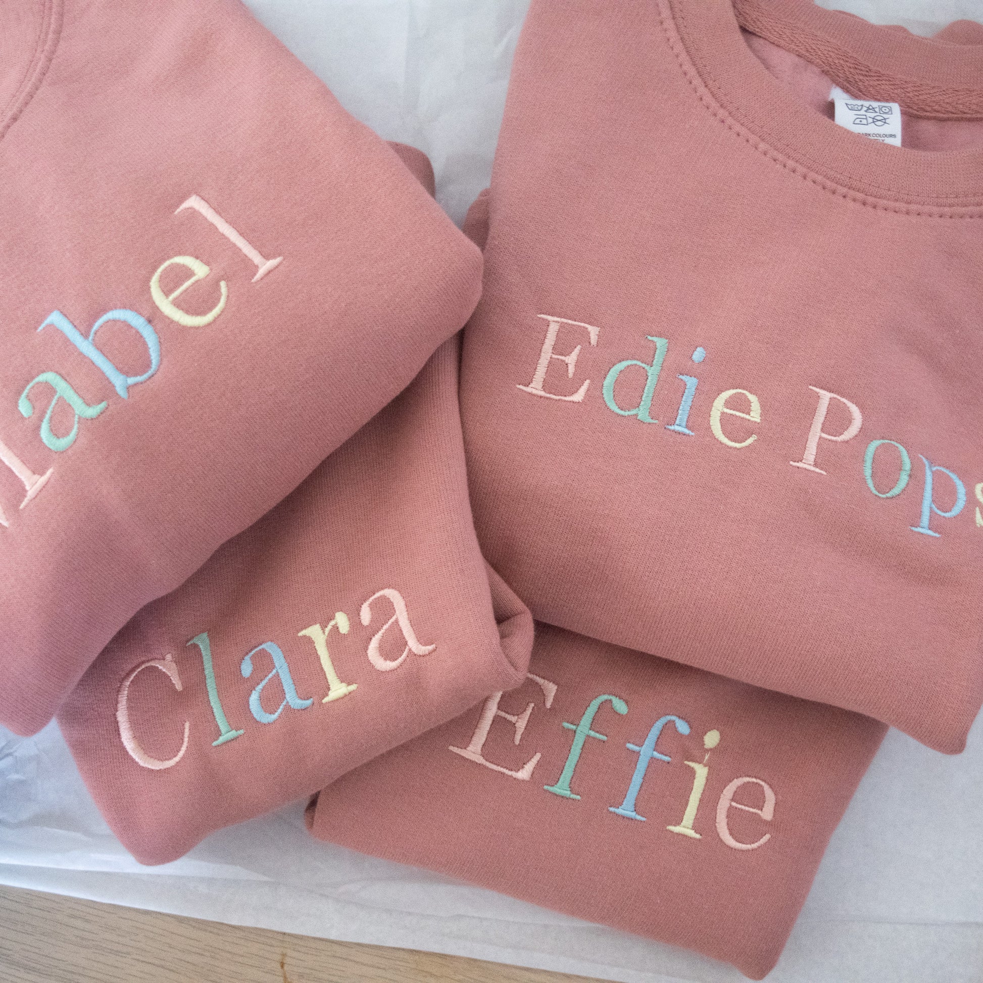kids custom embroidered personalised jumper in pink with rainbow pastel thread